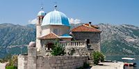 Our Lady of the Rocks, blue domed church in Kotor with mountains in the distance