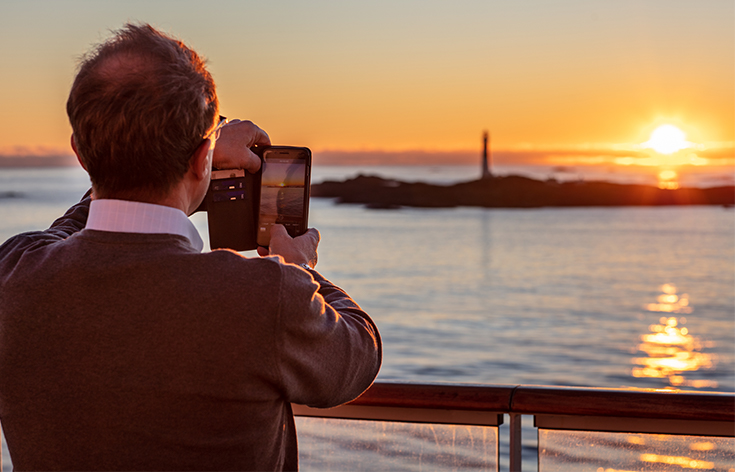 A man taking a photo of a sunset